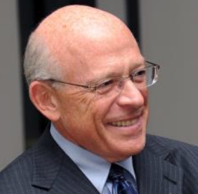 A headshot of Sheldon Berman, a male-presenting person, who smiles away from the camera.